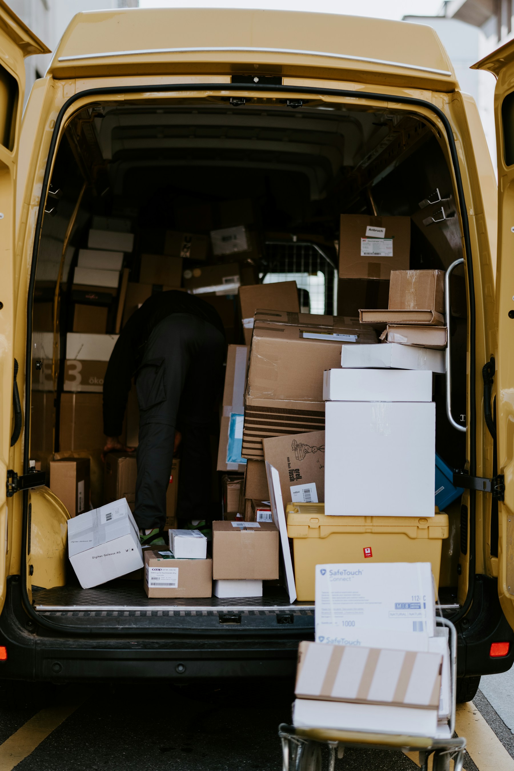 A mover loading boxes into the back of a delivery van